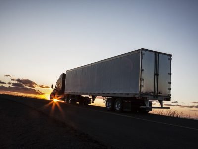 silhouette-of-a-commercial-truck-driving-on-a-hig-2023-11-27-05-02-41-utc-1